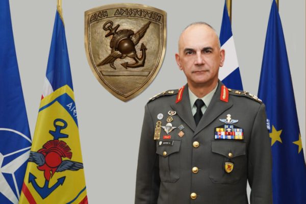 Ο Δημήτριος Χούπης με στρατιωτική στολή, πλαισιωμένος από σημαίες, τιμά την 25η Μαρτίου και την εθνική υπερηφάνεια.