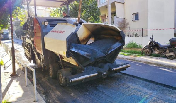 Μηχάνημα ασφαλτόστρωσης εργάζεται σε δρόμο του Δήμου Ηρακλείου Αττικής για τις προγραμματισμένες ασφαλτοστρώσεις.
