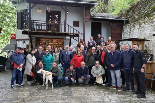 Ομάδα συμμετεχόντων στο δημοσιογραφικό συνέδριο της Περιφέρειας Θεσσαλίας στον Βόλο, με φόντο παραδοσιακό κτίριο.