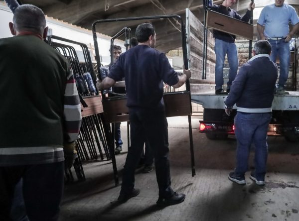 Άνδρες μεταφέρουν έπιπλα σε φορτηγό, πιθανώς ενόψει εκλογών την άνοιξη του 2026.