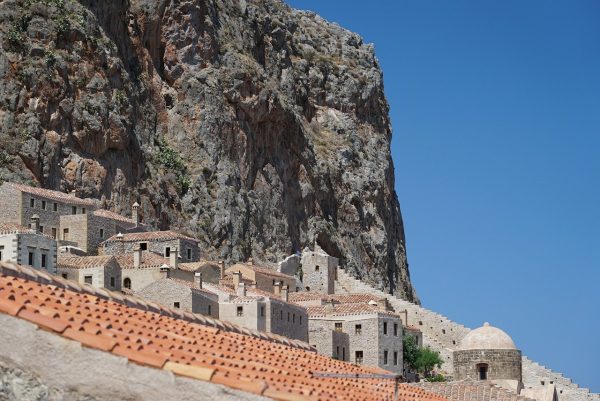 Η ακρόπολη της Μονεμβασιάς με τα πέτρινα σπίτια και τον βράχο να δεσπόζει στον γαλάζιο ουρανό.