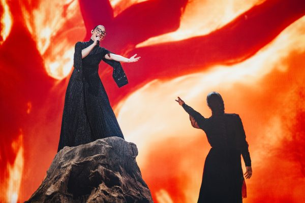 Η εκπρόσωπος της Ελλάδας στην Eurovision 2025 κατά τη διάρκεια της πρώτης πρόβας, με φόντο κόκκινες αποχρώσεις.