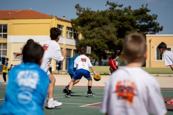 Μαθητές συμμετέχουν στο 3x3 Schools powered by ΔΕΗ, παίζοντας μπάσκετ σε σχολικό περιβάλλον.