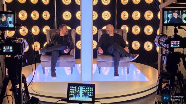 Ο Θέμης Γεωργαντάς και ο Γιώργος Λάγιος συνομιλούν στο πλατό της εκπομπής «After Dark» με φόντο τα φώτα.