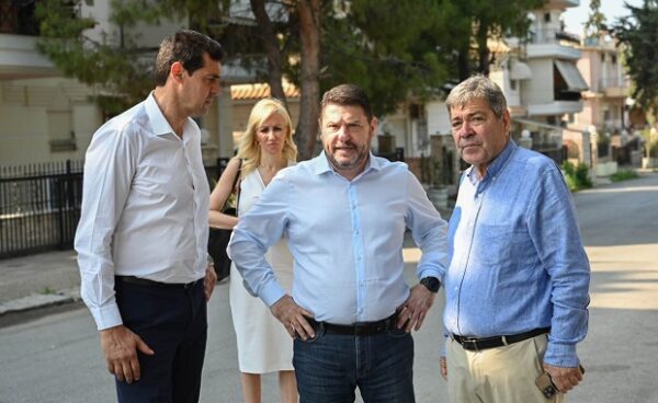 Ο Νίκος Χαρδαλιάς στον Ασπρόπυργο συζητά για τις γειτονιές και τις βασικές υποδομές με άλλους άνδρες και μια γυναίκα.