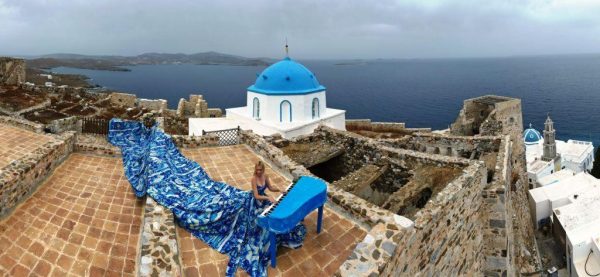 Γυναίκα παίζει πιάνο σε πρωτότυπη περιβαλλοντική δράση στην Αστυπάλαια με φόντο το μπλε του Αιγαίου.