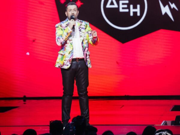 Ο παρουσιαστής των MAD VMA 2025 με πολύχρωμο σακάκι και δερμάτινο παντελόνι στη σκηνή του Mega.