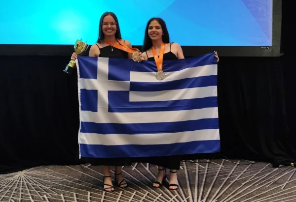 Δυο 17χρονες Ελληνίδες παγκόσμιες πρωταθλήτριες στον διαγωνισμό πληροφορικής της Microsoft κρατούν την ελληνική σημαία και μετάλλια.