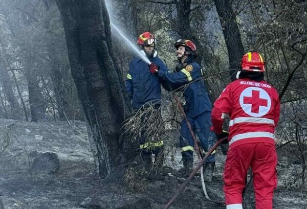 Εθελοντές Σαμαρείτες – Διασώστες του Ελληνικού Ερυθρού Σταυρού επιχειρούν στο Κορωπί για την κατάσβεση της πυρκαγιάς.