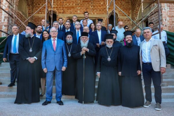 Ο Τασούλας με κληρικούς και άλλους παρευρισκόμενους μπροστά από το Ιωνικό Κέντρο, ένα συγκλονιστικό έργο.
