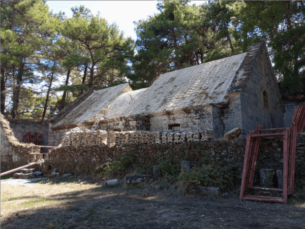 Ανακαινισμένα κτίρια και λιθόστρωτες διαδρομές στο Κάστρο Ζακύνθου, με υλικά για την αποκατάσταση του δικτύου περιήγησης.