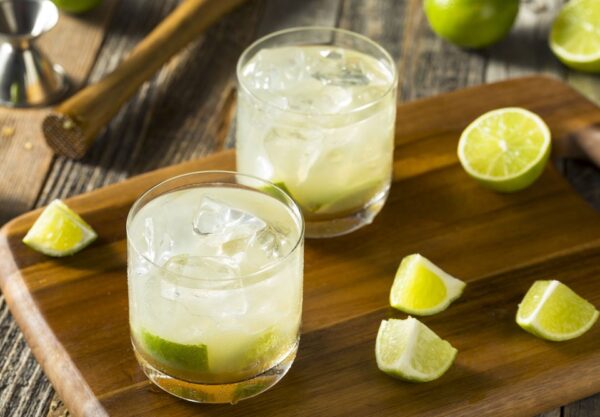 Δύο δροσιστικά ποτήρια με caipirinha και φρέσκα lime, ιδανικά για το θέατρο ΔΡΟΜΟΣ.