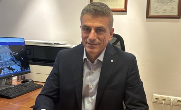 Ο Θάνος Λίπας, ο νέος Πρόεδρος του Ελληνικού Κτηματολογίου, κάθεται στο γραφείο του.