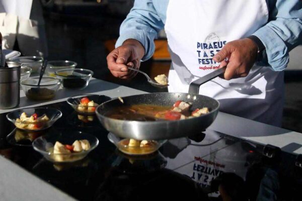Chef ετοιμάζει πιάτα με θαλασσινά και άλλα εδέσματα στο PIRAEUS TASTE FESTIVAL, Sea Food and More.