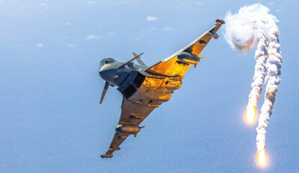 Μαχητικό αεροσκάφος Eurofighter εκτοξεύει φωτοβολίδες κατά τη διάρκεια πτήσης, ενισχύοντας την αμυντική ικανότητα.