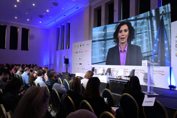 Ομιλήτρια σε οθόνη κατά τη διάρκεια του 7ου Diversity in Business Conference, όπου η Ελλάδα προωθεί τη συμπερίληψη.