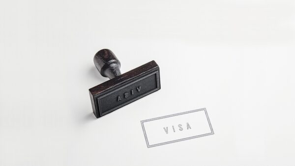 Σφραγίδα με τη λέξη VISA και χαρτί με τη λέξη VISA, σχετικά με τη μεταρρύθμιση της ταξιδιωτικής βίζας της ΕΕ.