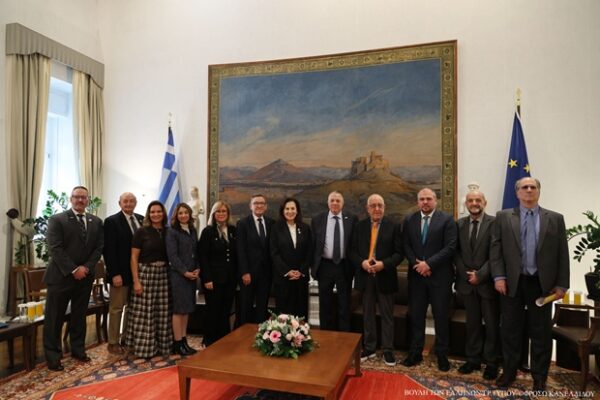 Συνάντηση του Προέδρου της Βουλής με μέλη του Δ.Σ. της Πα.Δ.Ε.Ε. σε επίσημο χώρο με σημαίες και έργο τέχνης.