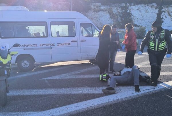 Ερυθρός Σταυρός παρέχει πρώτες βοήθειες σε τραυματία τροχαίου στον Περιφερειακό Υμηττού, με ασθενοφόρο και προσωπικό παρόντα.