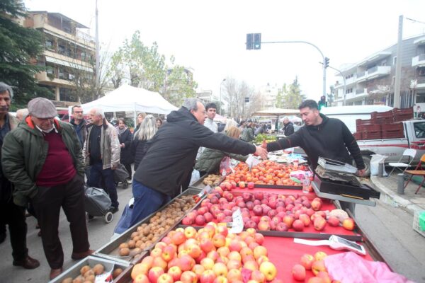 Σωκράτης Φάμελλος χαιρετά πωλητή σε λαϊκή αγορά, υποστηρίζοντας τον αγώνα για ανοιχτές λαϊκές αγορές.