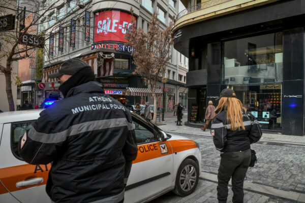 Αστυνομικοί της Δημοτικής Αστυνομίας Αθηνών με περιπολικό, σε δρόμο με καταστήματα, στο πλαίσιο δικαστικού μπλοκαρίσματος δημοτικών τελών.