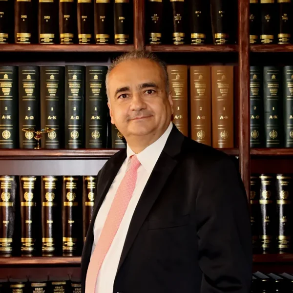 Ο δικηγόρος Γιώργος Τέμπης σε επίσημη εμφάνιση μπροστά από ράφια με νομικά βιβλία.
