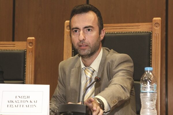 Ο Σεβαστίδης σε συνεδρίαση, όπου συζητιέται το όνομά του, με πιθανή ιδιότητα δικαστή ή εισαγγελέα.