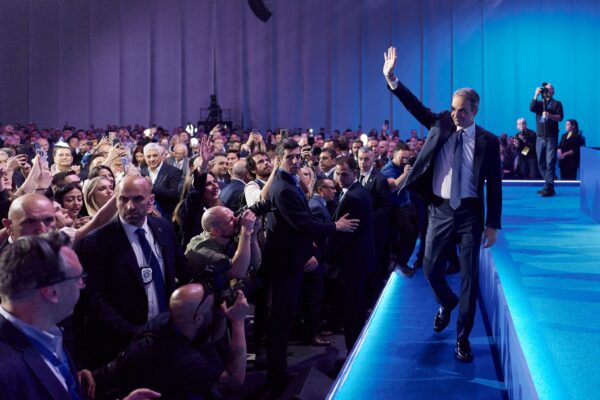 Ο Κ. Μητσοτάκης χαιρετά το κοινό, καθώς βαδίζει προς το βήμα για την ομιλία του για την ισχυρή Ελλάδα.