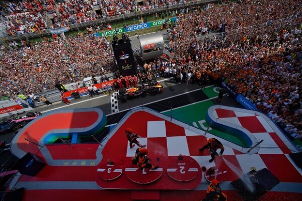 Αναβάτες της FORMULA 1 γιορτάζουν την νίκη τους στο βάθρο μετά το 7ο Grand Prix Ισπανίας, με πλήθος θεατών να παρακολουθεί.